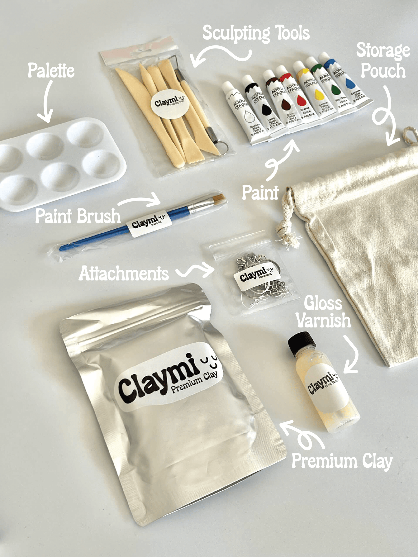Claymi product set including palette, paint brush, paint, storage pouch, attachments, premium clay, and gloss varnish on a white background.