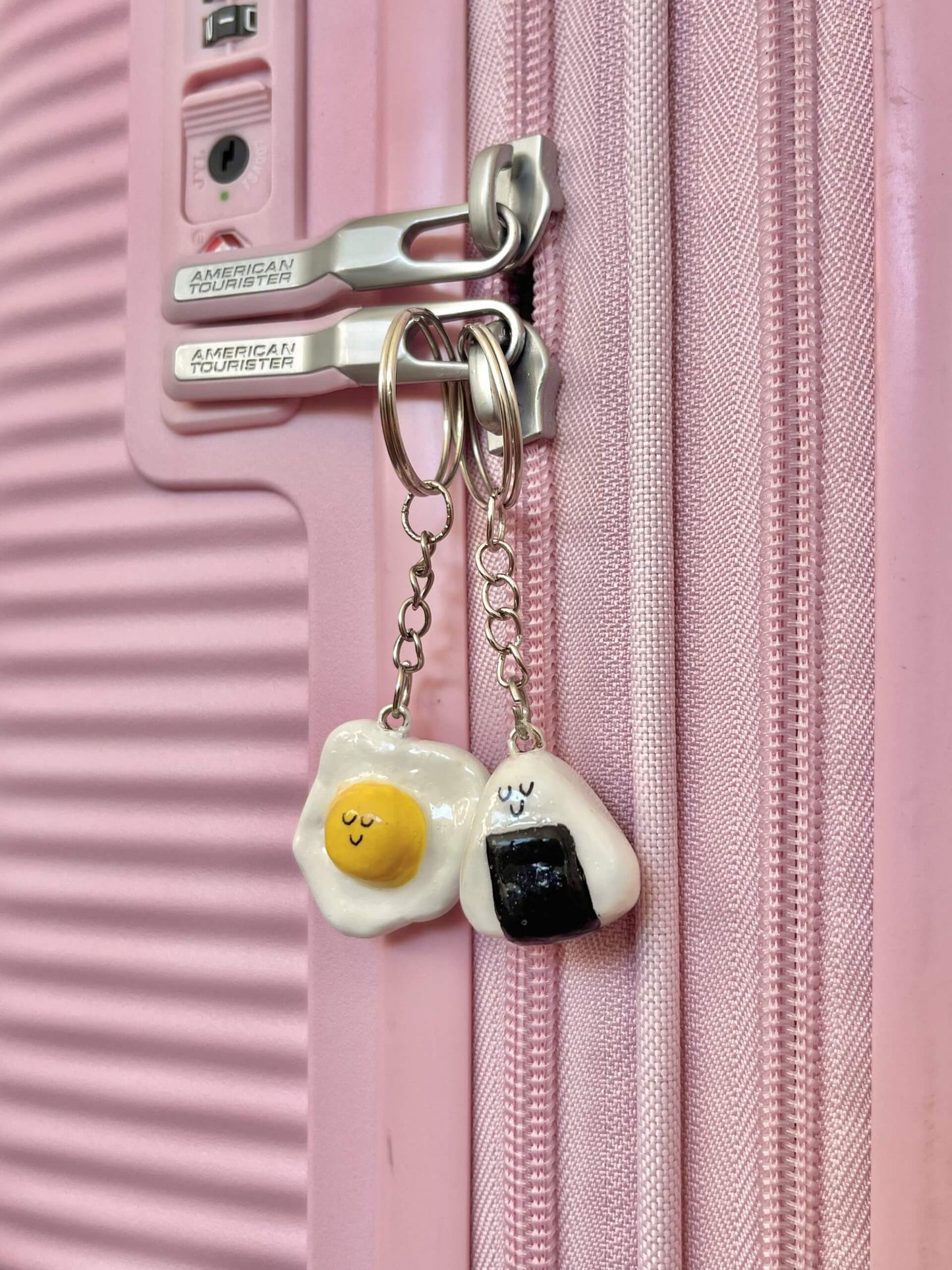 A handmade air dry clay charm, crafted from a DIY clay charm kit, hanging from the zipper of a pastel-colored backpack. This cute, custom keychain features a kawaii-style design, showcasing the creative potential of at-home crafting activities for teens and hobbyists. Ideal for personalizing bags, purses, or accessories with handmade flair.