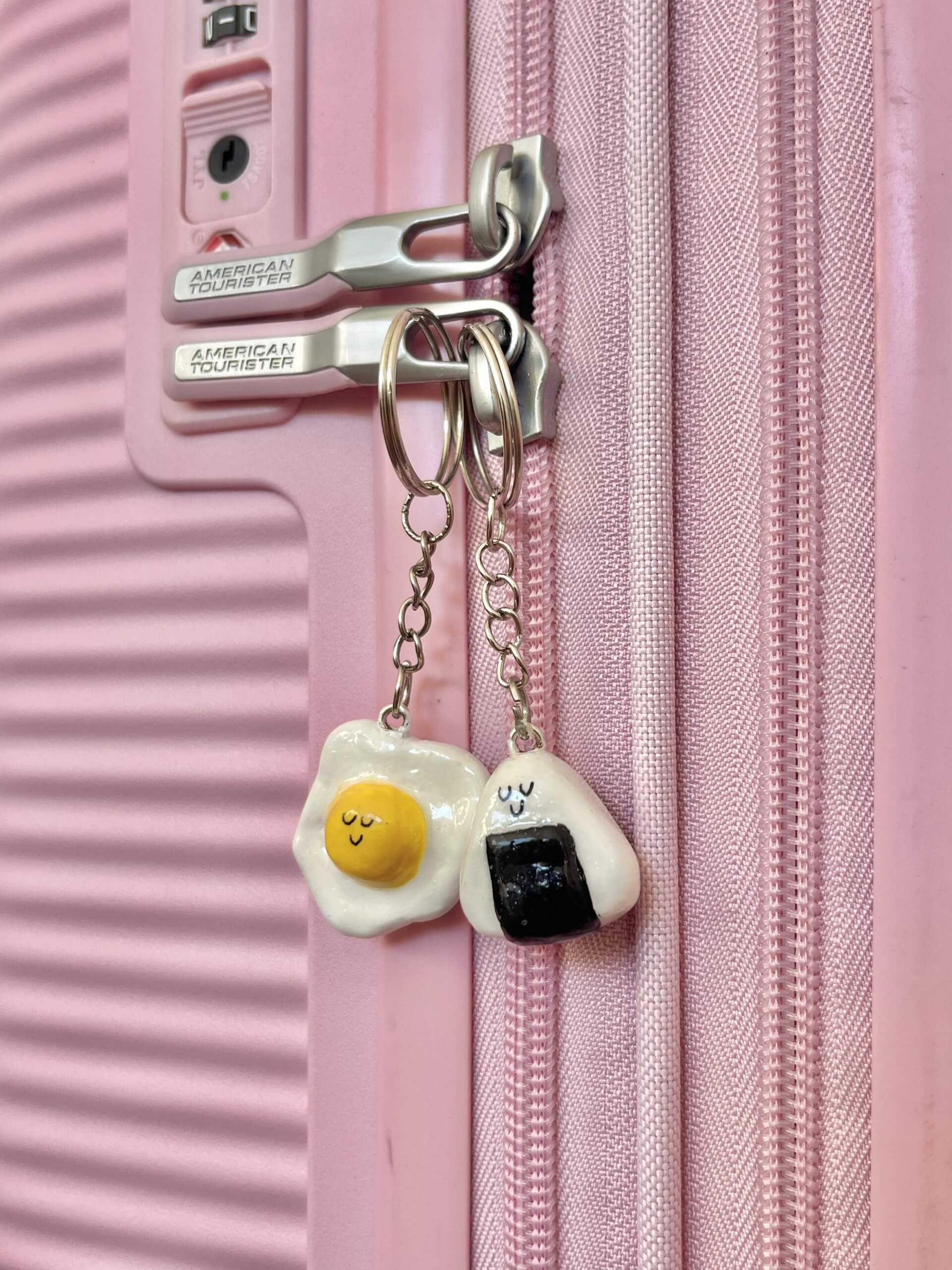 A handmade air dry clay charm, crafted from a DIY clay charm kit, hanging from the zipper of a pastel-colored backpack. This cute, custom keychain features a kawaii-style design, showcasing the creative potential of at-home crafting activities for teens and hobbyists. Ideal for personalizing bags, purses, or accessories with handmade flair.